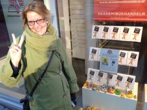 Ethel Forsberg vid Akademibokhandeln med boken i skyltfönstret